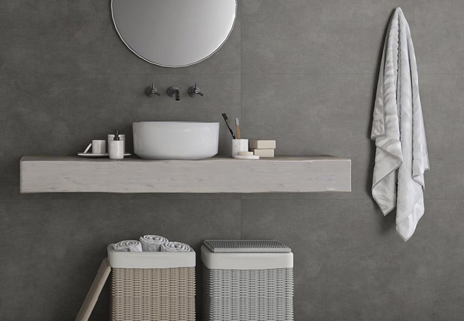 Уборная с раковиной, корзинами для белья и полотенцем на стене.