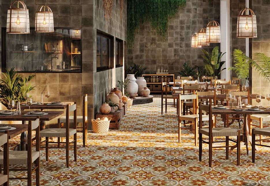 Интерьер ресторана с деревянными столами, стульями и цветочным ковром на полу.