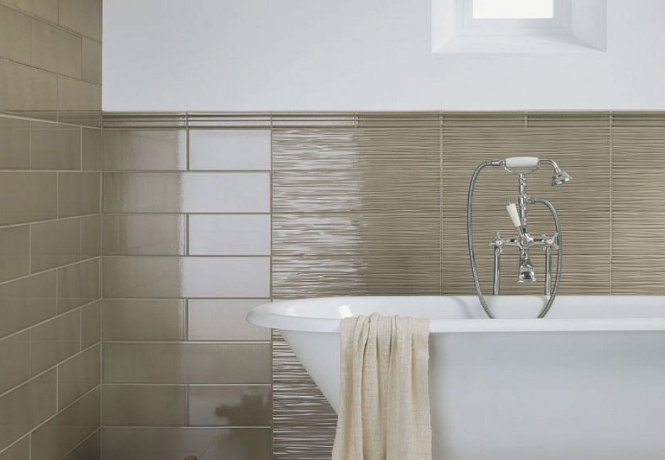 Ванная с бежевой плиткой, ванной и полотенцем